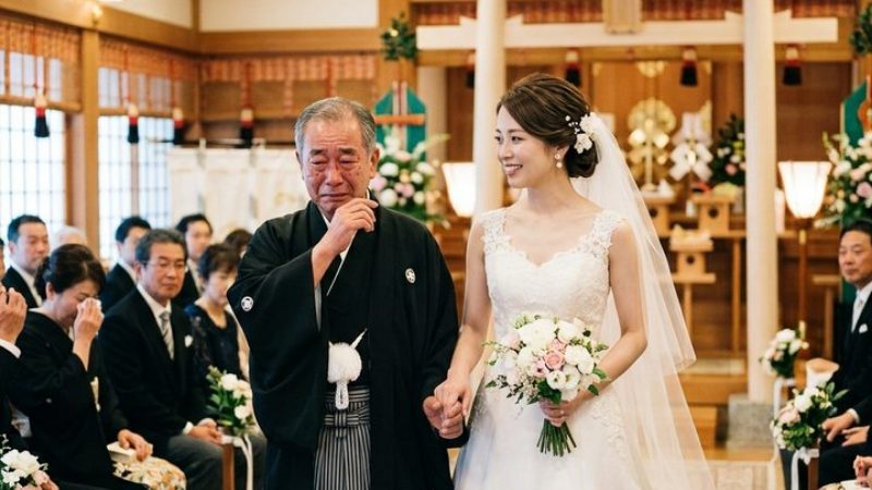 和装の新郎新婦を親族が囲んでいる挙式会場