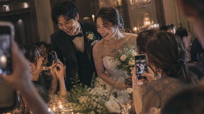 披露宴でゲストが新郎新婦にスマートフォンを向けている様子