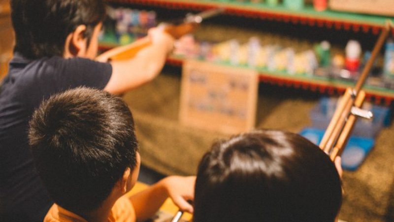 縁日の射的に並んでいる子どもたち