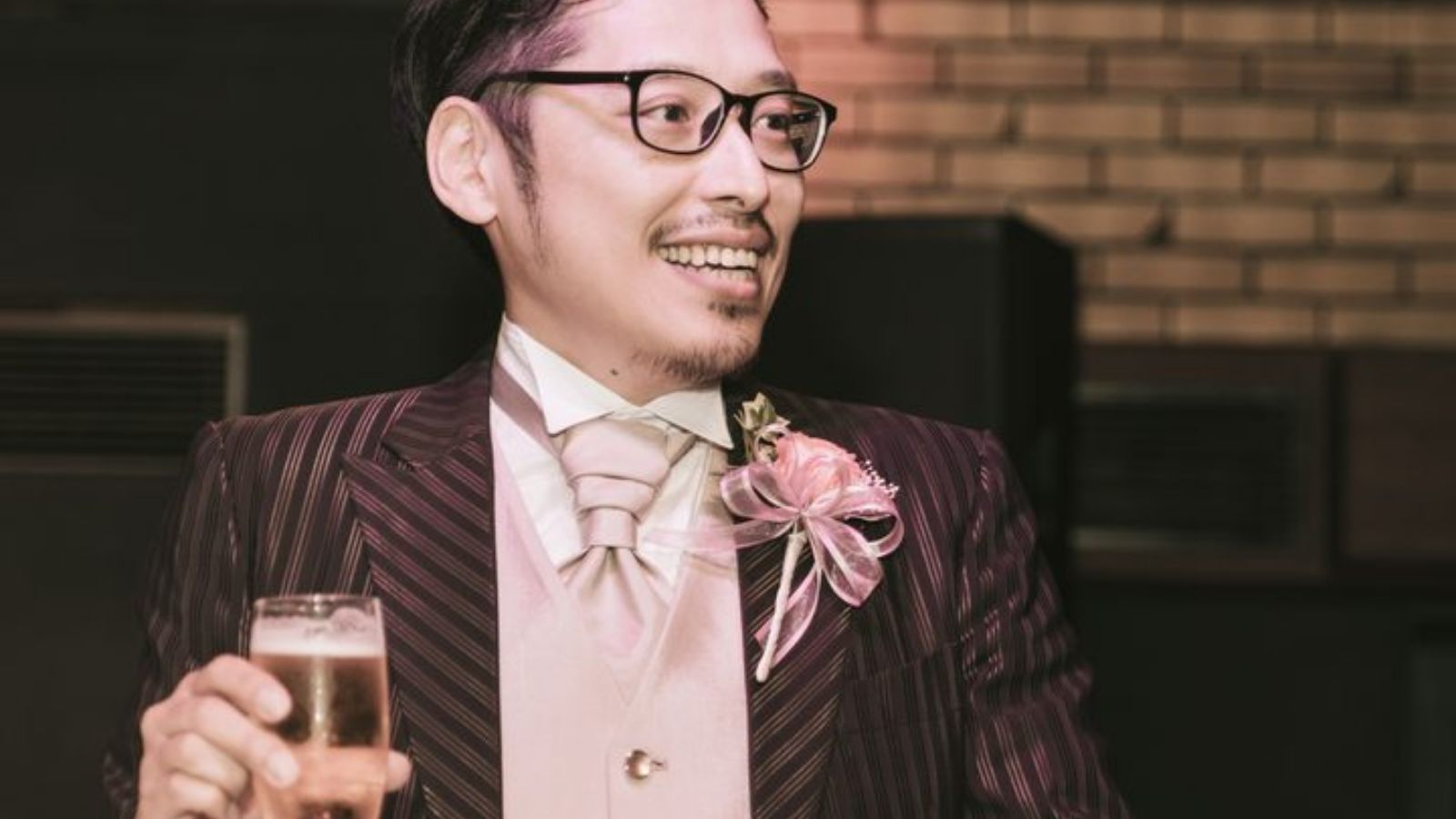 グラスを持って会場を見渡している男性